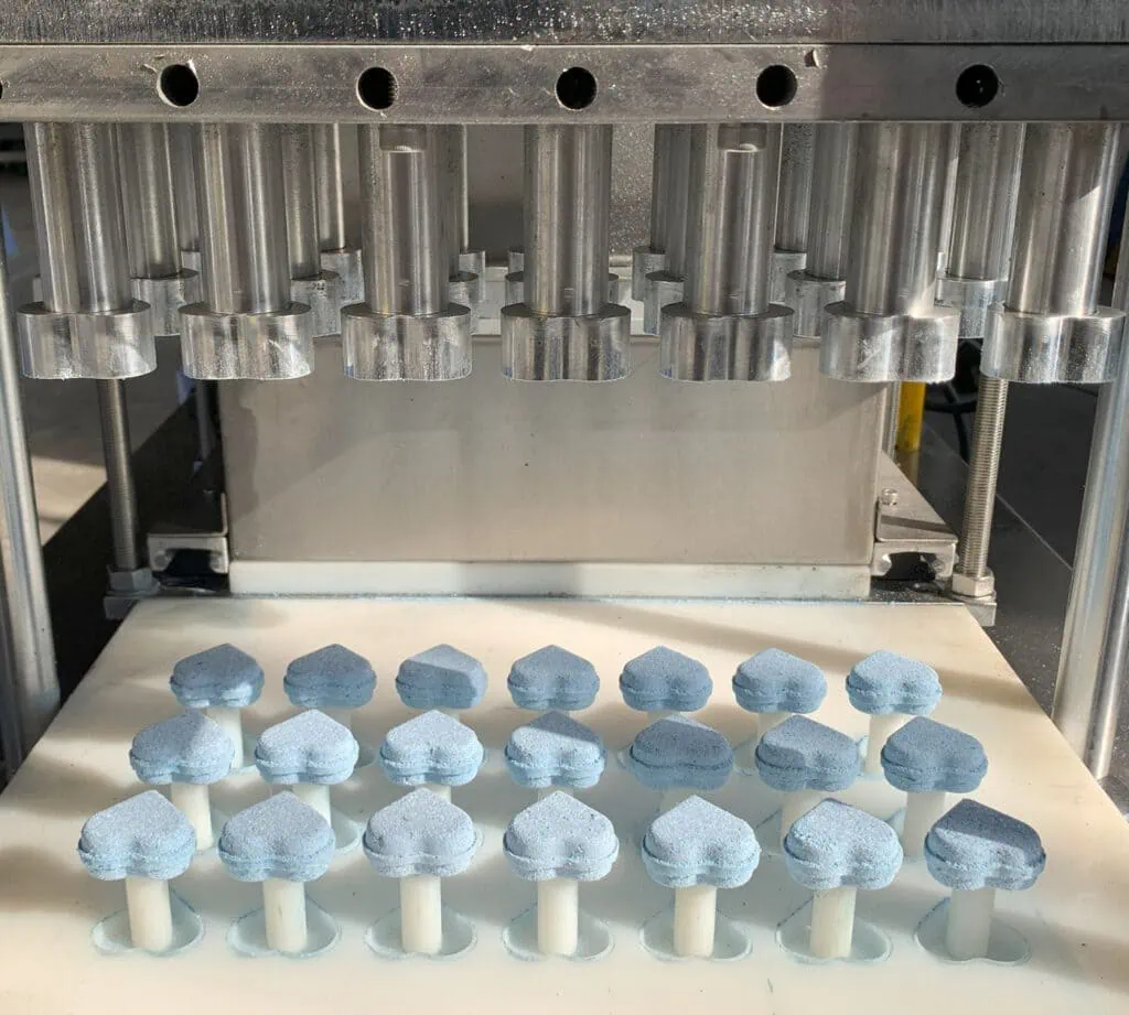 Heart-shaped bath bombs pressed in sets of 21, enabling efficient production with custom molds