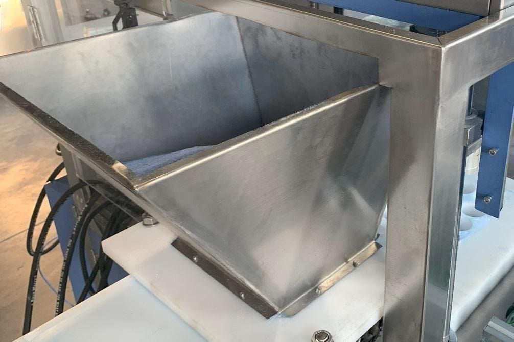 Stainless steel hopper for bath bomb machine, ensuring efficient and consistent powder delivery to the pressing chamber.